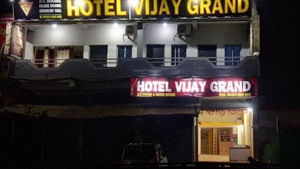 Un hôtel appelé HOTEL VIJAY GRAND, dont l’enseigne indique la présence de chambres climatisées et de chambres de luxe.