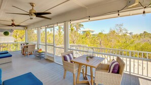 A covered outdoor area with wicker furniture, ceiling fans, and a view of the surrounding landscape. - Little Gasparilla Island Escape on Private Island! (Placida)
