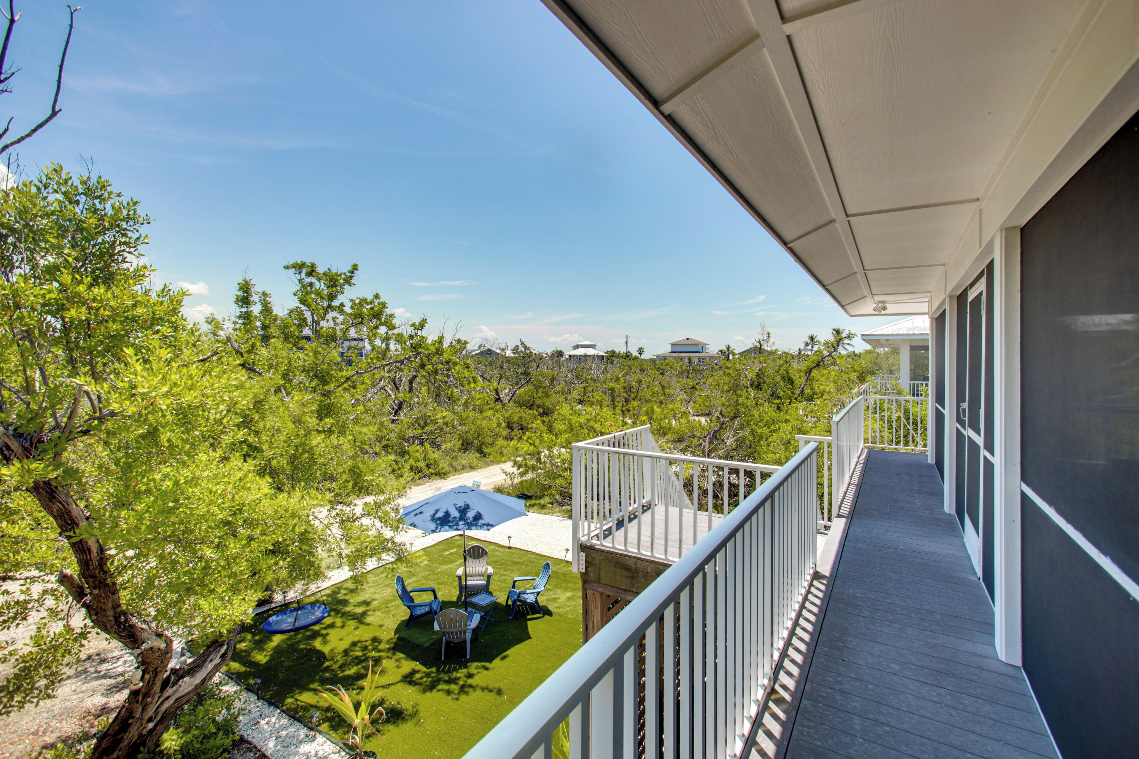 A balcony with a view of a landscaped area, including a lawn and a pool.