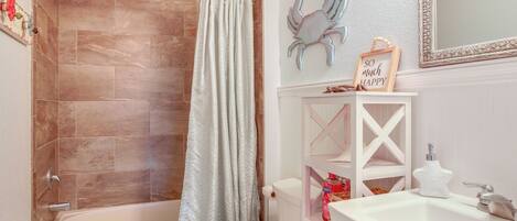 A bathroom with a bathtub, toilet, and sink.