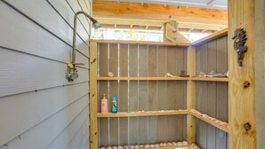 A wooden shelf unit with a metal faucet, shelves with seashells, and a decorative seahorse. - Little Gasparilla Island Escape on Private Island! (Placida)