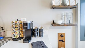 Una cocina con cafetera, tazas y un libro de visitas sobre la encimera.