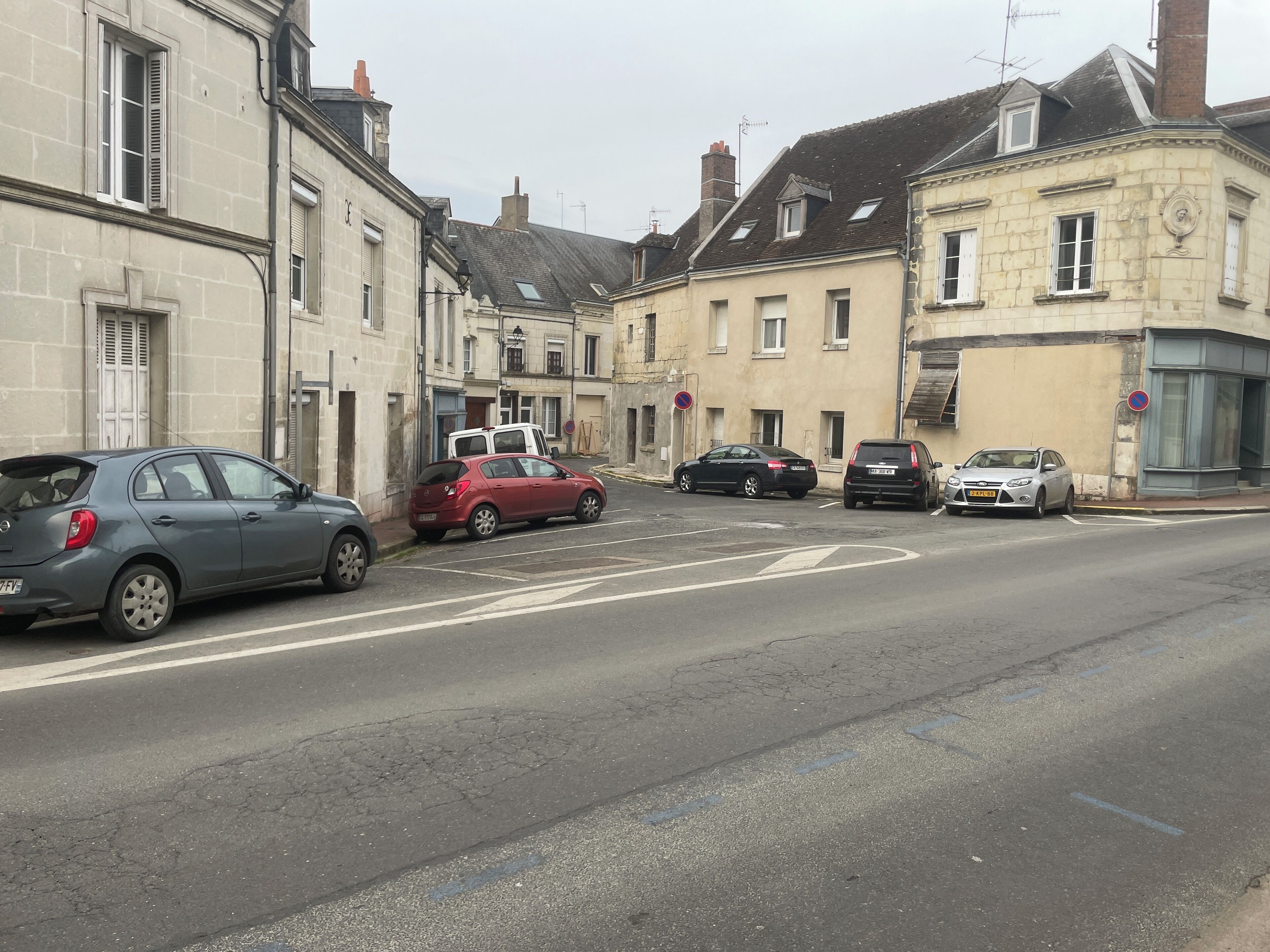 A street with parked cars and buildings.