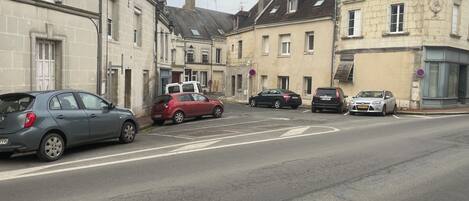 A street with parked cars and buildings.