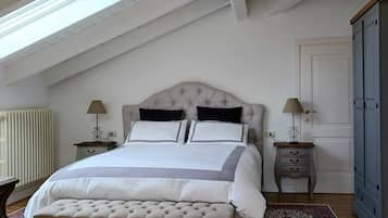 Ein Schlafzimmer mit einem großen Bett, zwei Nachttischen, einem Kleiderschrank und einem Oberlicht.