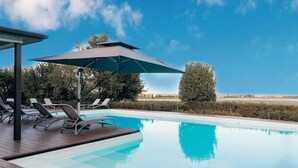 A swimming pool with lounge chairs and a covered area. - Tuscany Garden Inn (Castel San Pietro Terme)