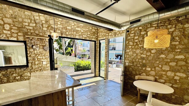 A modern kitchen with a stone wall, a large island, and a view of the outdoor area.