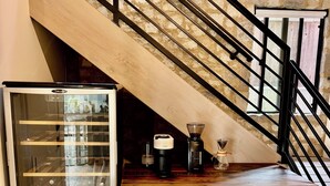 A kitchen with a built-in wine cooler, a coffee maker, and a wooden countertop.