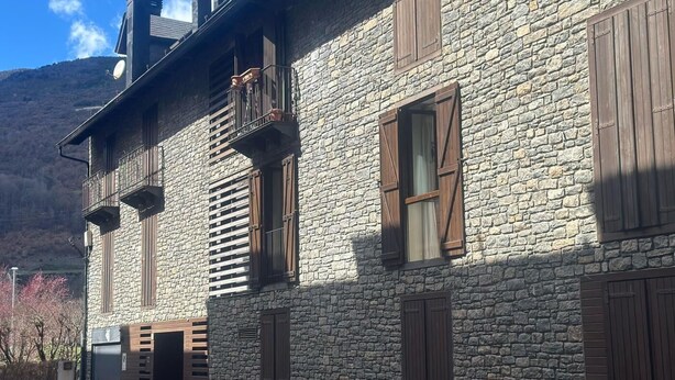 Un edificio de piedra con varias ventanas y un balcón.