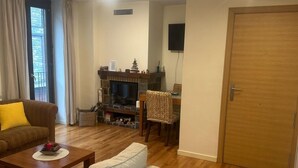Una sala de estar con chimenea, un sofá, una mesa de centro y un comedor con sillas.