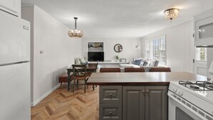 A modern kitchen with a central island, white cabinetry, and a built-in stove. - [New Listing] Walk To Beach, Main St, Harbor. Beautifully Renovated - Captain Gosnold Village (Hyannis)