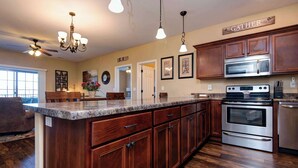 A kitchen with wooden cabinets, a granite countertop, stainless steel appliances, and pendant lighting. - 51-06 Eagles Ridge Retreat, Spacious walk-in.  Balcony, mountain views, indoor/outdoor pools/splash pads.  Close to SDC. (Branson)