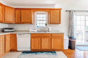 A kitchen with wooden cabinets, a dishwasher, a toaster, and a window with a view. - My Blue Heaven | Game Area | 4 BDR | Pet Friendly (Albrightsville)