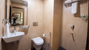 Ein Badezimmer mit Waschbecken, Toilette, Spiegel, Handtuchhalter und Dusche.