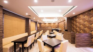 Ein moderner Konferenzraum mit einem langen Tisch, mehreren Stühlen, einer Couch und einer Rezeption.
