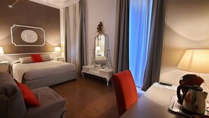 A hotel room with a bed, a desk, a chair, a lamp, a mirror, and a kettle. - Rooms Palazzo Groppallo  (Genoa)