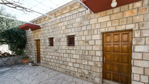 Un edificio de piedra con una puerta de madera y un ventanal pequeño.