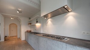 A modern kitchen with a central island, built-in gas stove, and recessed lighting.