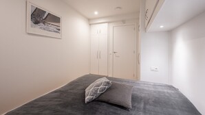A bedroom with a bed, a wardrobe, and a framed picture on the wall. - Apartment in Knokke with Sea View (KNOKKE-HEIST)