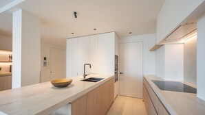 A modern kitchen with a central island, a sink, and a built-in oven.