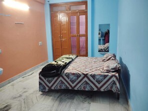 A bedroom with a bed, a wardrobe, and a mirror. - Ramakantam Home Stay (Faizabad)