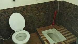 A small bathroom with a toilet and a squat toilet. - Ramakantam Home Stay (Faizabad)