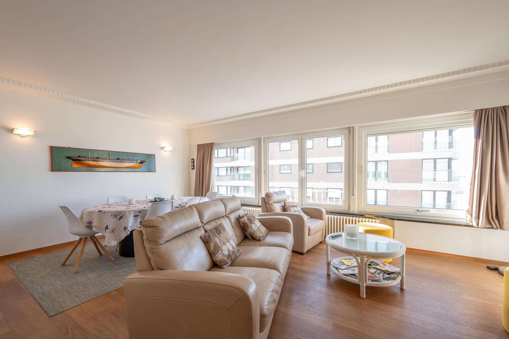 A living room with a sofa set, a dining table, and a coffee table.