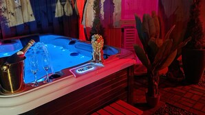 A hot tub with a key-shaped decoration, a lion statue, and a bottle of champagne. - Ferienhaus Mefady Jünkerath (Jünkerath)