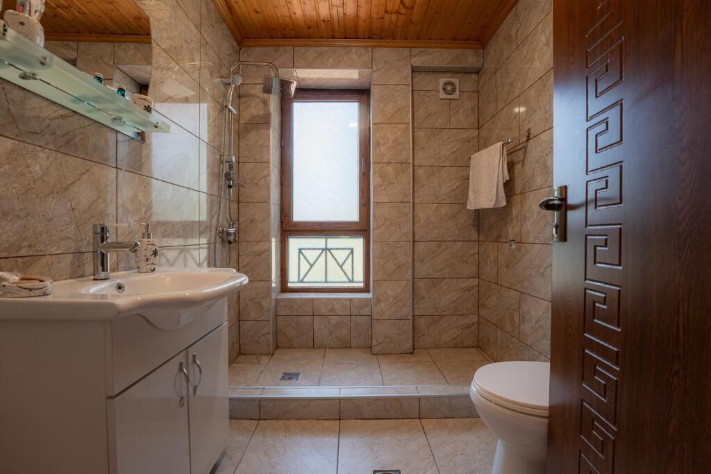 Ein Badezimmer mit Dusche, Toilette und Waschbecken.