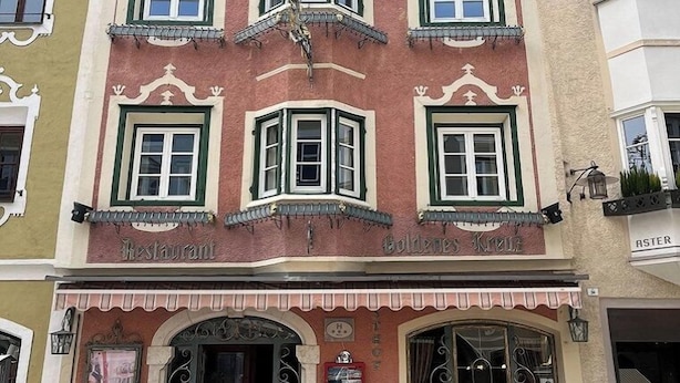 A building with a restaurant named "Restaurant Aster" on the ground floor. There are outdoor tables and chairs in front of the entrance. - Hotel Goldenes Kreuz (Vipiteno)