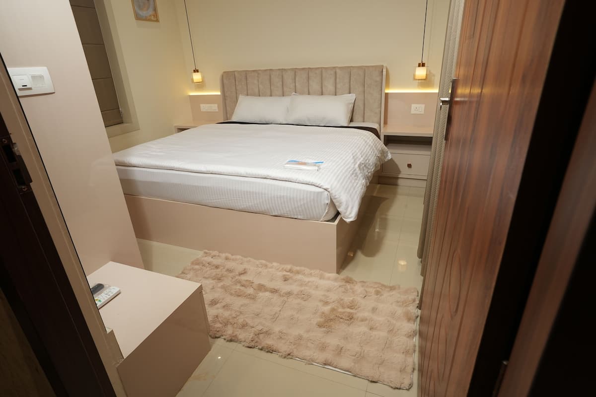 A bedroom with a bed, bedside tables, and a fluffy rug.