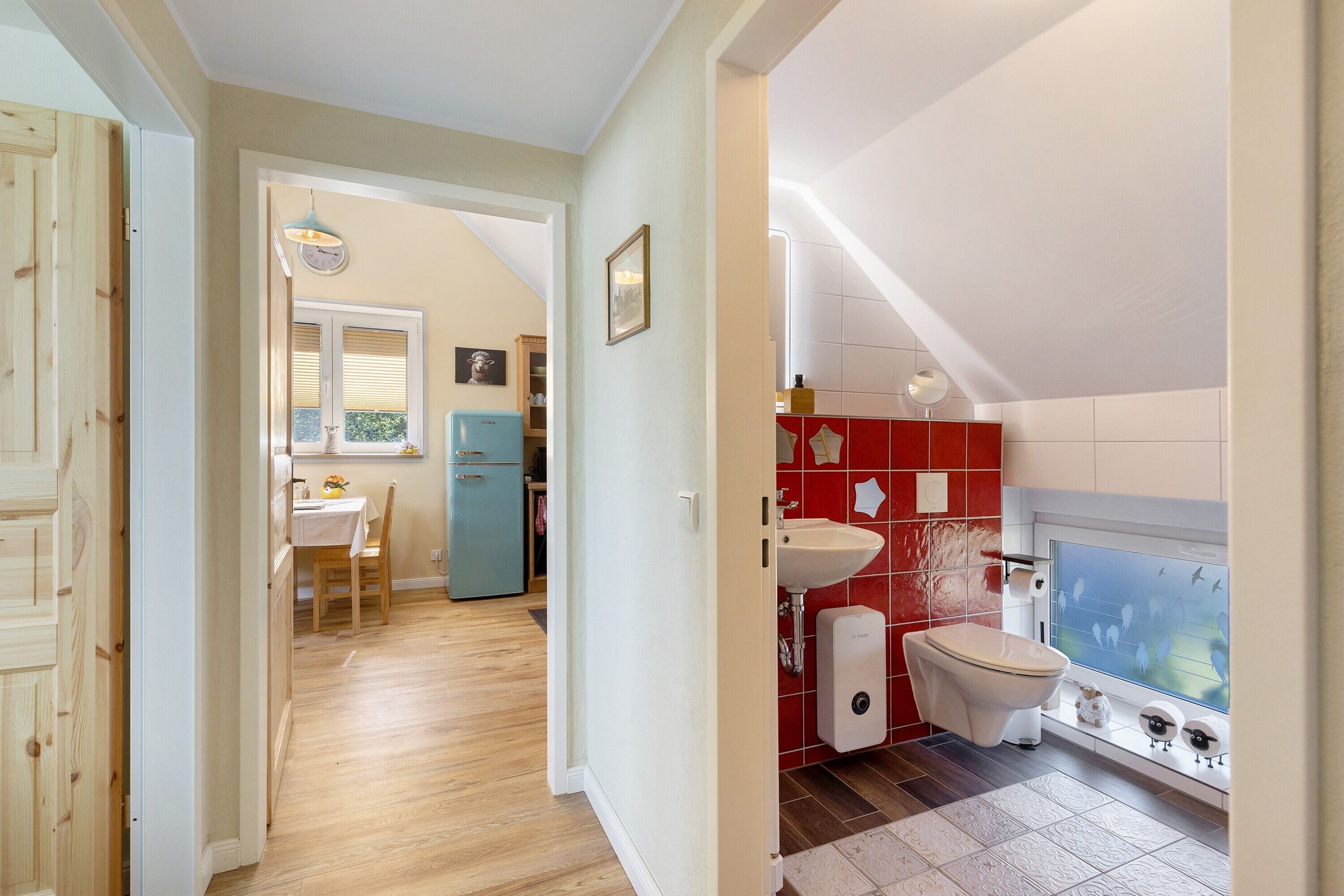 Eine kleine Küche mit Spüle, Toilette und Fenster mit Blick auf einen Balkon.