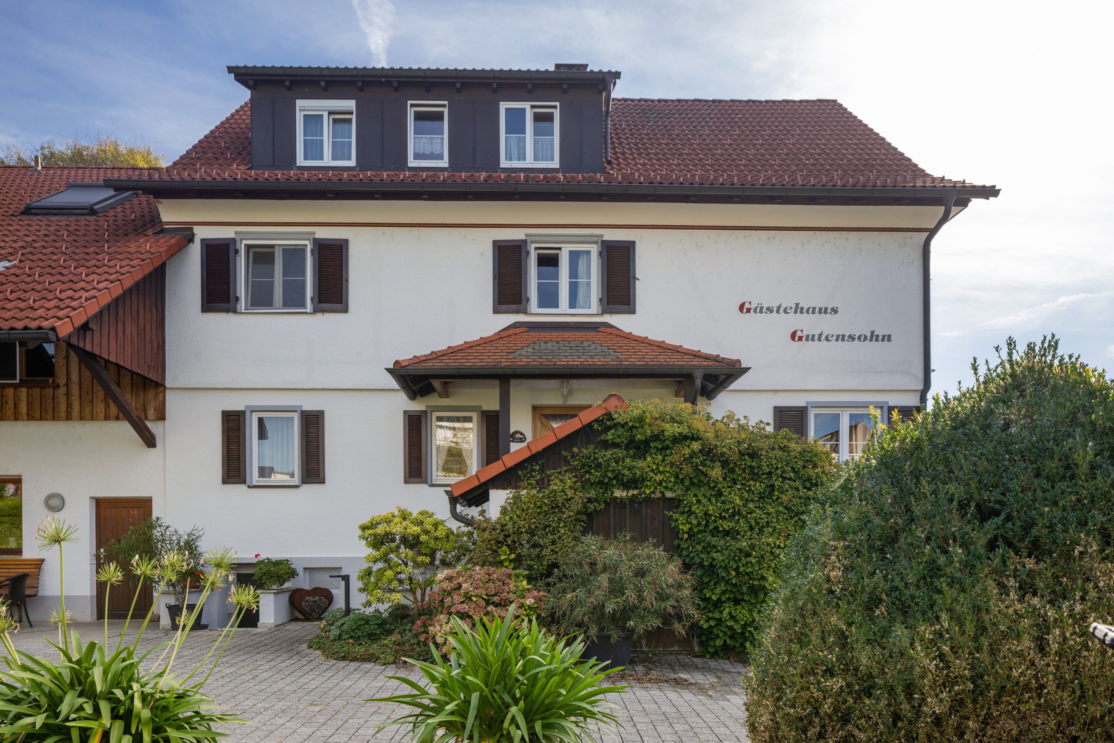 Un bâtiment à deux étages, sur lequel on peut lire l’inscription « Gästehaus Gutensohn », ce qui indique qu’il s’agit d’une maison d’hôtes.