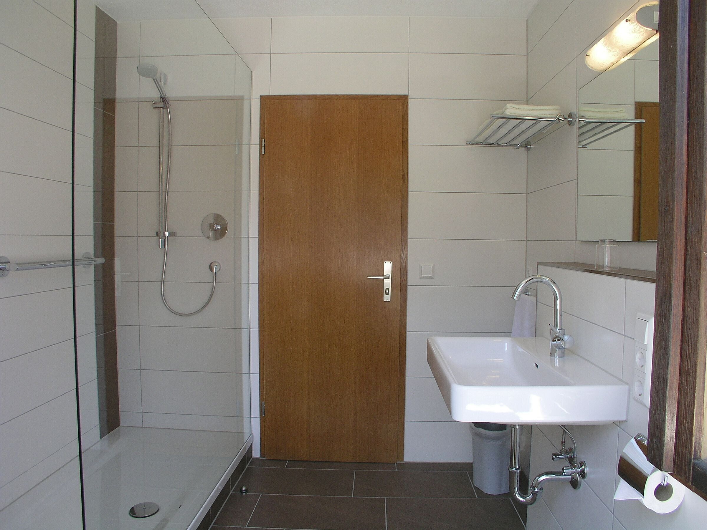 Ein Badezimmer mit Dusche, Waschbecken und Toilette.