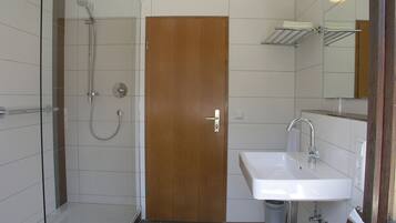 Ein Badezimmer mit Dusche, Waschbecken und Toilette.