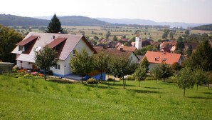 A rural house with a red roof, surrounded by green fields and trees. - Waibel Apartment, 60 sqm, 1 Bedroom, Terrace, Sleeps up to 3 Guests (Überlingen)
