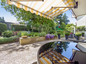 Un espace extérieur abrité, doté d’un jardin, de sièges et d’une surface réfléchissante.