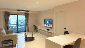 A modern hotel room with a balcony, a TV, a desk, and a sofa. - Avana Residence (Bangkok)
