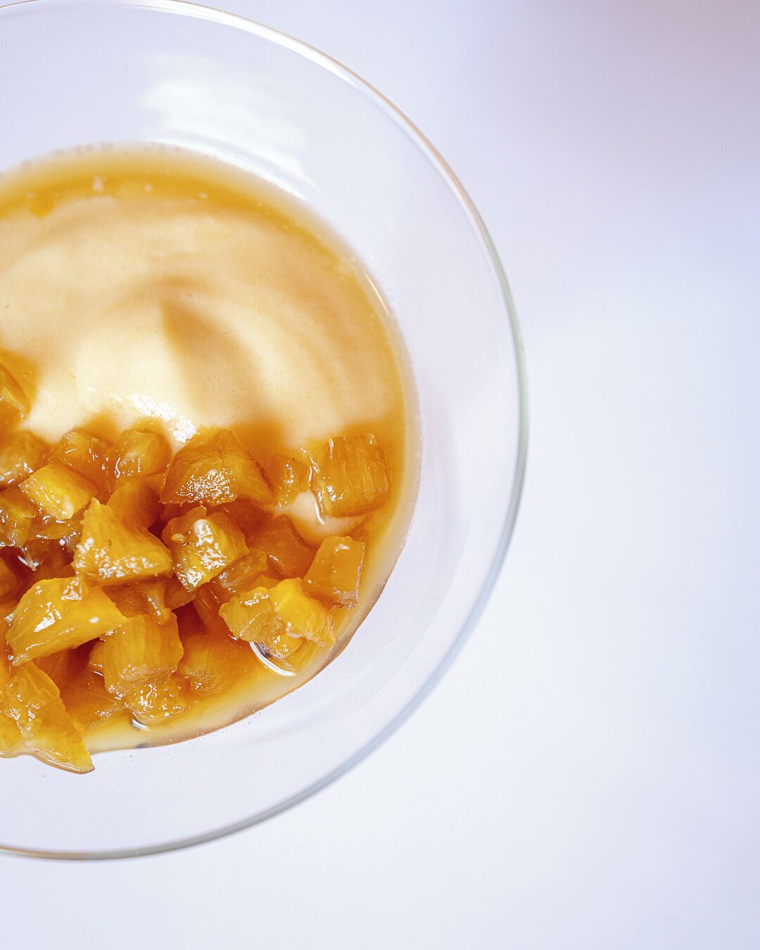 A bowl of fruit compote with a creamy topping.