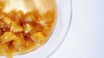 A bowl of fruit compote with a creamy topping.