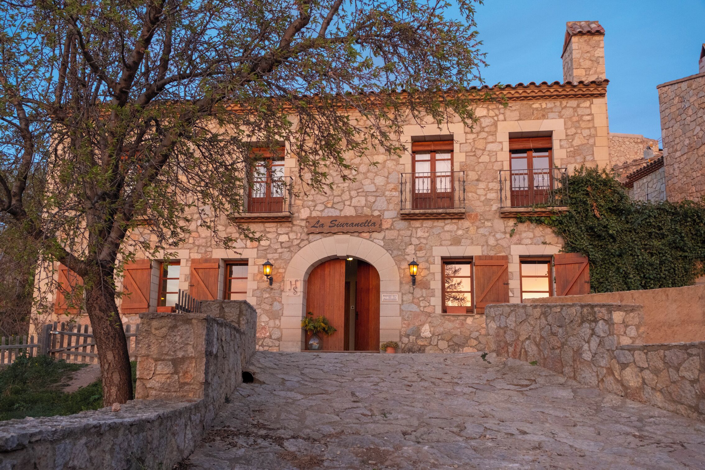 A stone building with a wooden door and arched entrance, labeled "La Suanella."