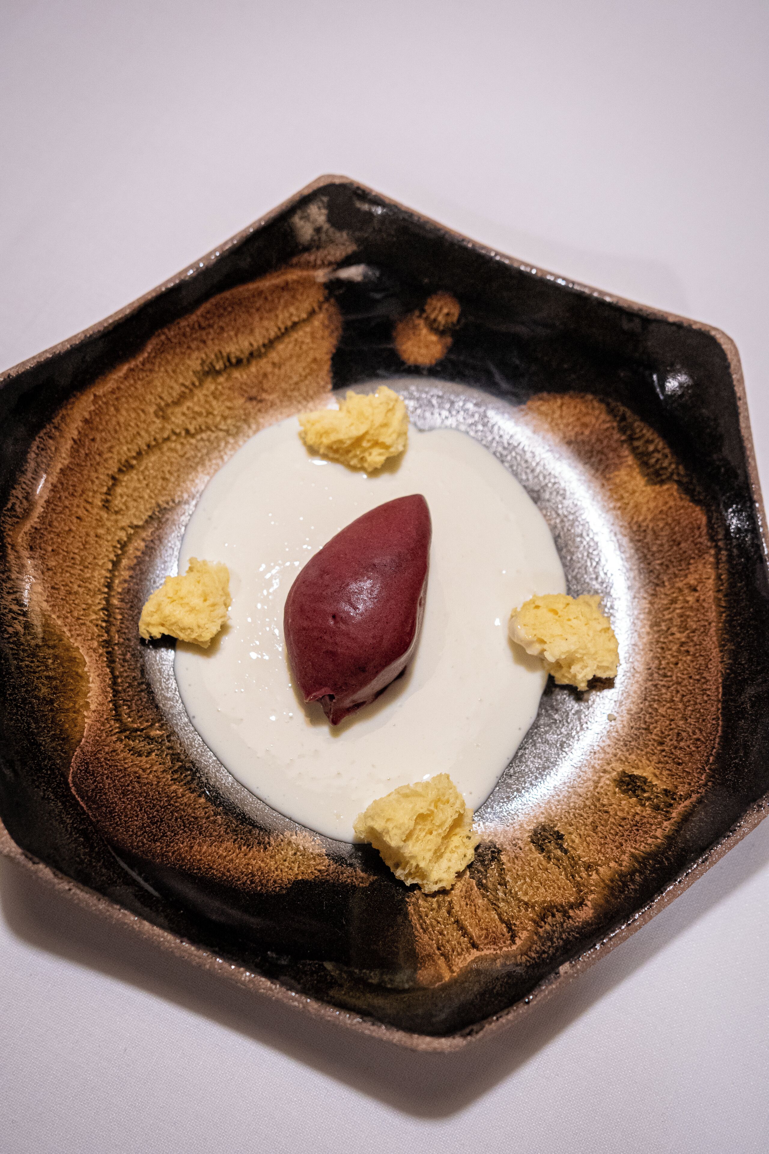 Ein Dessert auf einem Keramikteller mit strukturierter Oberfläche.