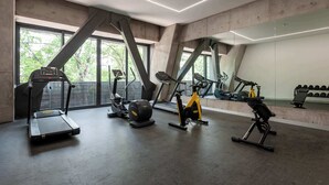 Et moderne fitnesscenter med løbebånd, crosstrainer og motionscykel.