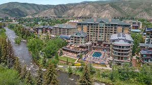A hotel with multiple buildings, a pool area, and a river running through the property. - LUXE Riverfront Mountain Retreat | Walk to Gondola (Avon)
