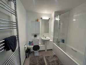 Une salle de bain avec des toilettes, un lavabo et une douche.