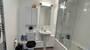 Um banheiro moderno com vaso sanitário, pia e chuveiro.