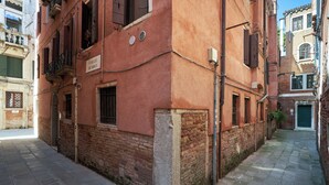 A narrow street with buildings on either side, a sign reading 'Calle Bembo,' and a green door at the end of the street. - Ca' dell'Arte - San Giacomo (Venezia)