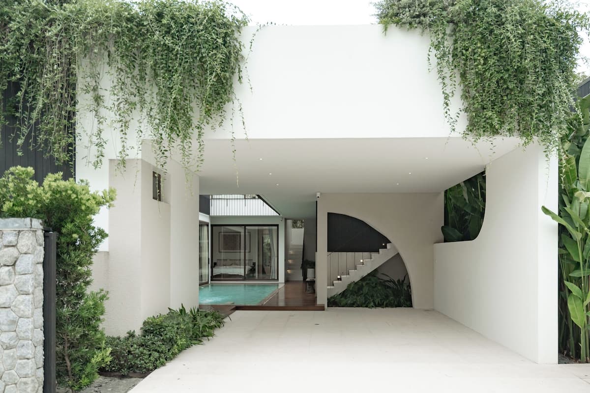 Uma casa moderna com piscina, escada e vegetação.