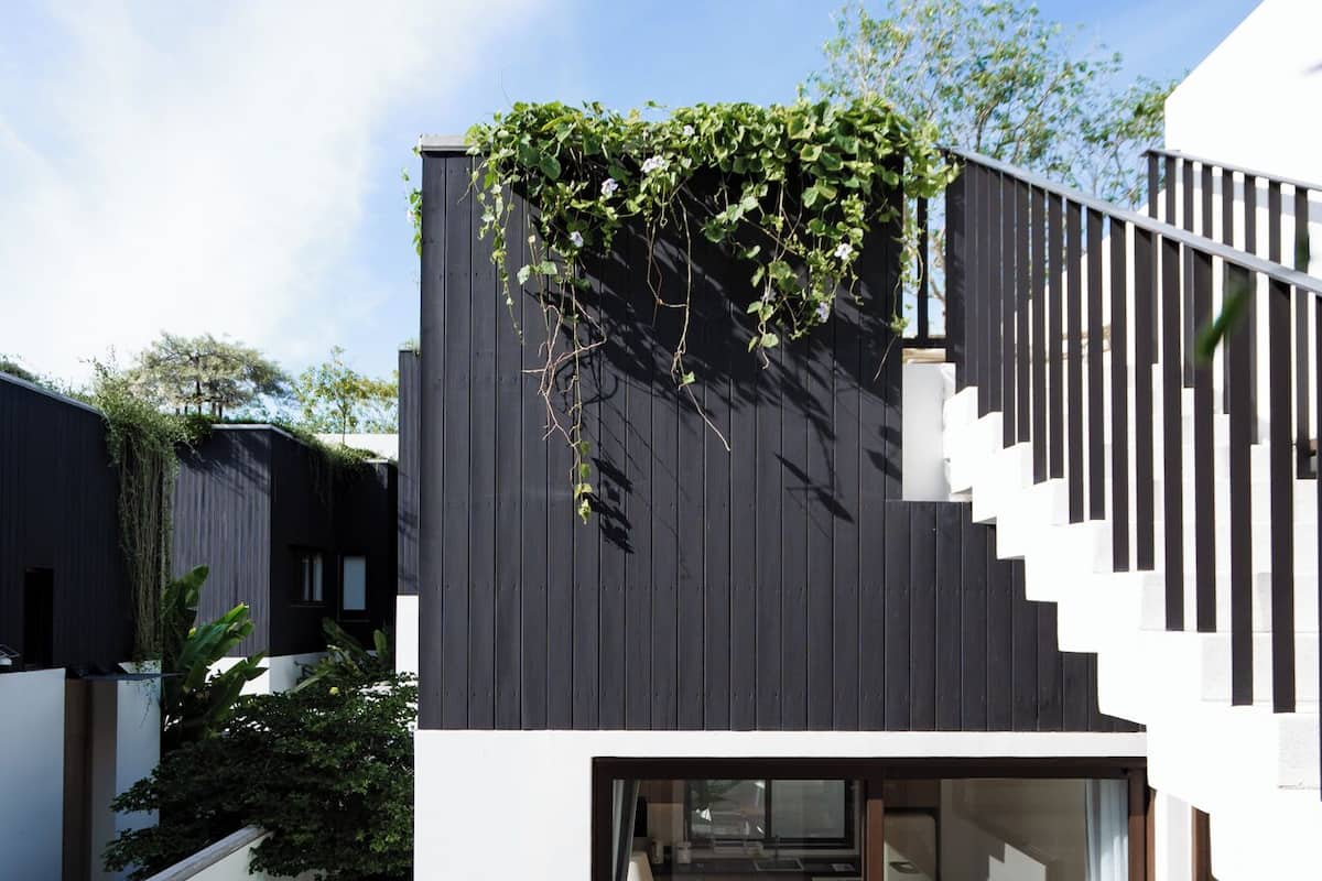 Uma casa moderna com piscina, escada e área de jantar.