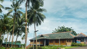 A resort with thatched-roof buildings, palm trees, and a welcoming sign. - Blue Deep Resort powered by Cocotel (Padre Burgos)